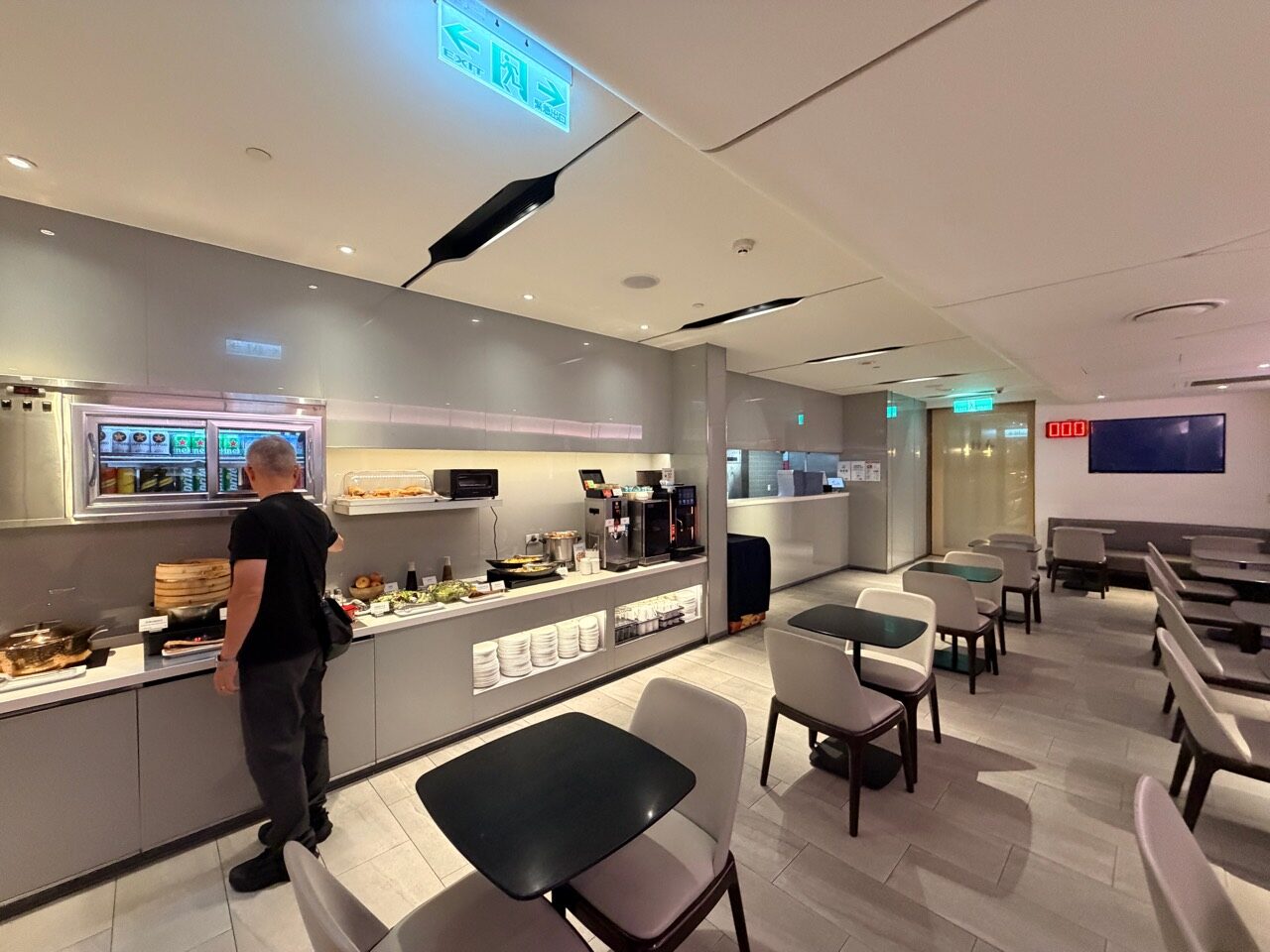 華航 D4 貴賓室的用餐桌、自助餐檯、咖啡機與冷藏飲料櫃