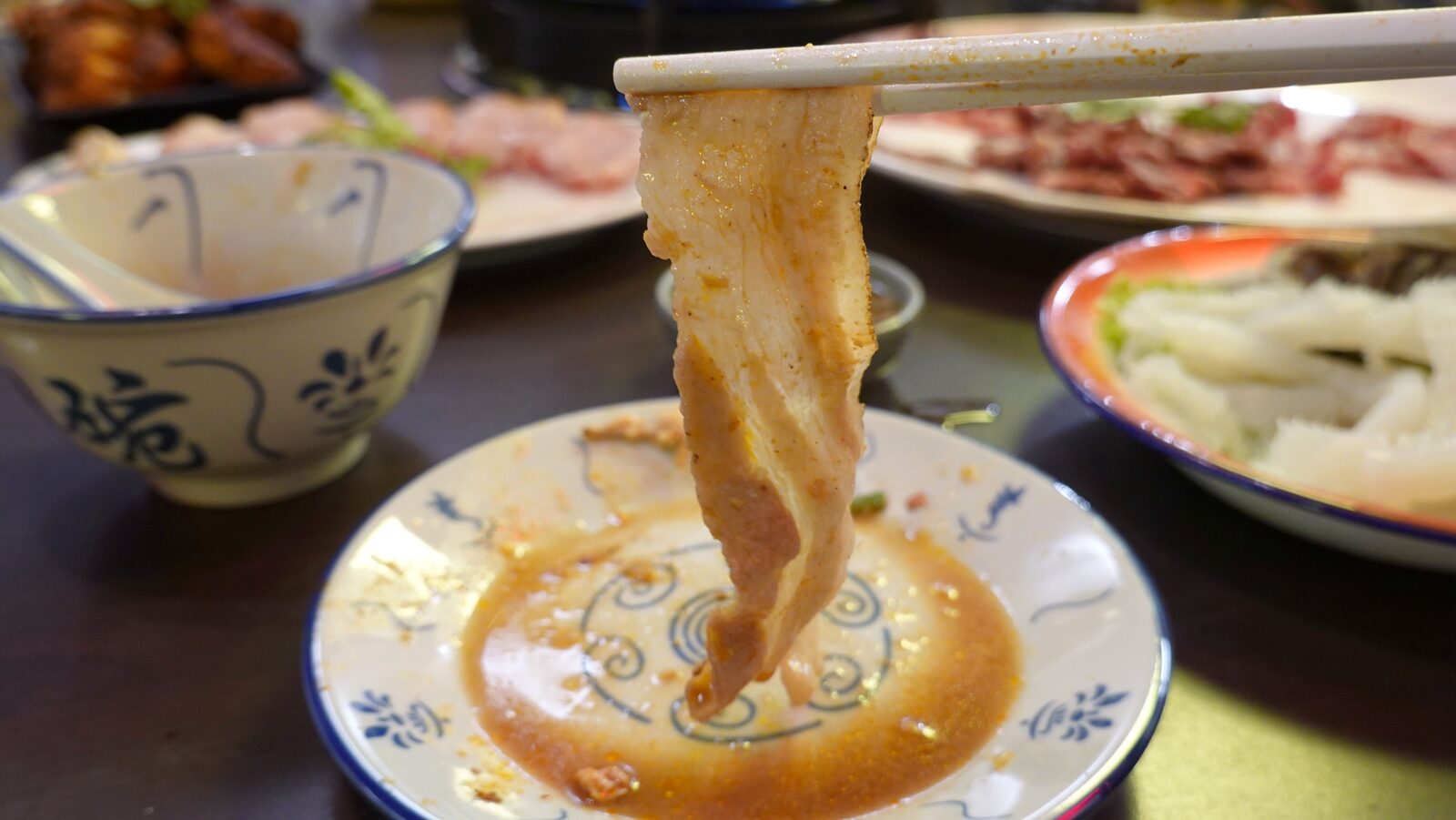 데친 돼지고기를 소스에 찍는 모습