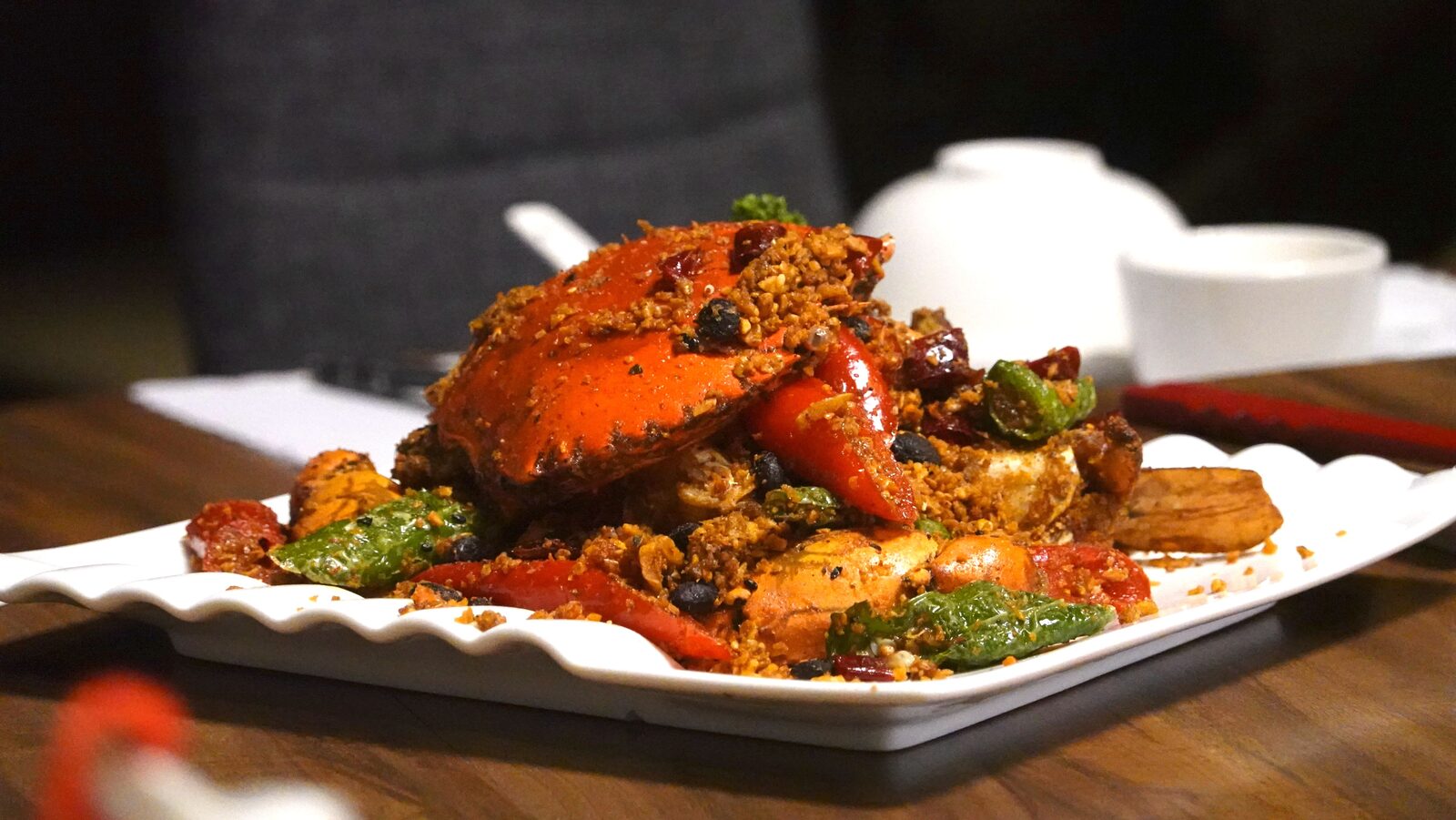 Jing Ying Cantonese Cuisine의 피항식 머드크랩, 노릇한 마늘 튀김과 고추, 더우츠가 가득 덮인 모습