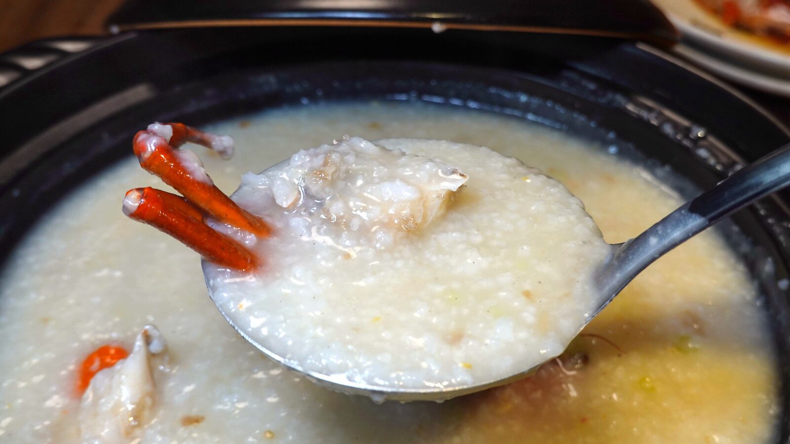 국자로 떠 올린 머드크랩 죽과 게 다리