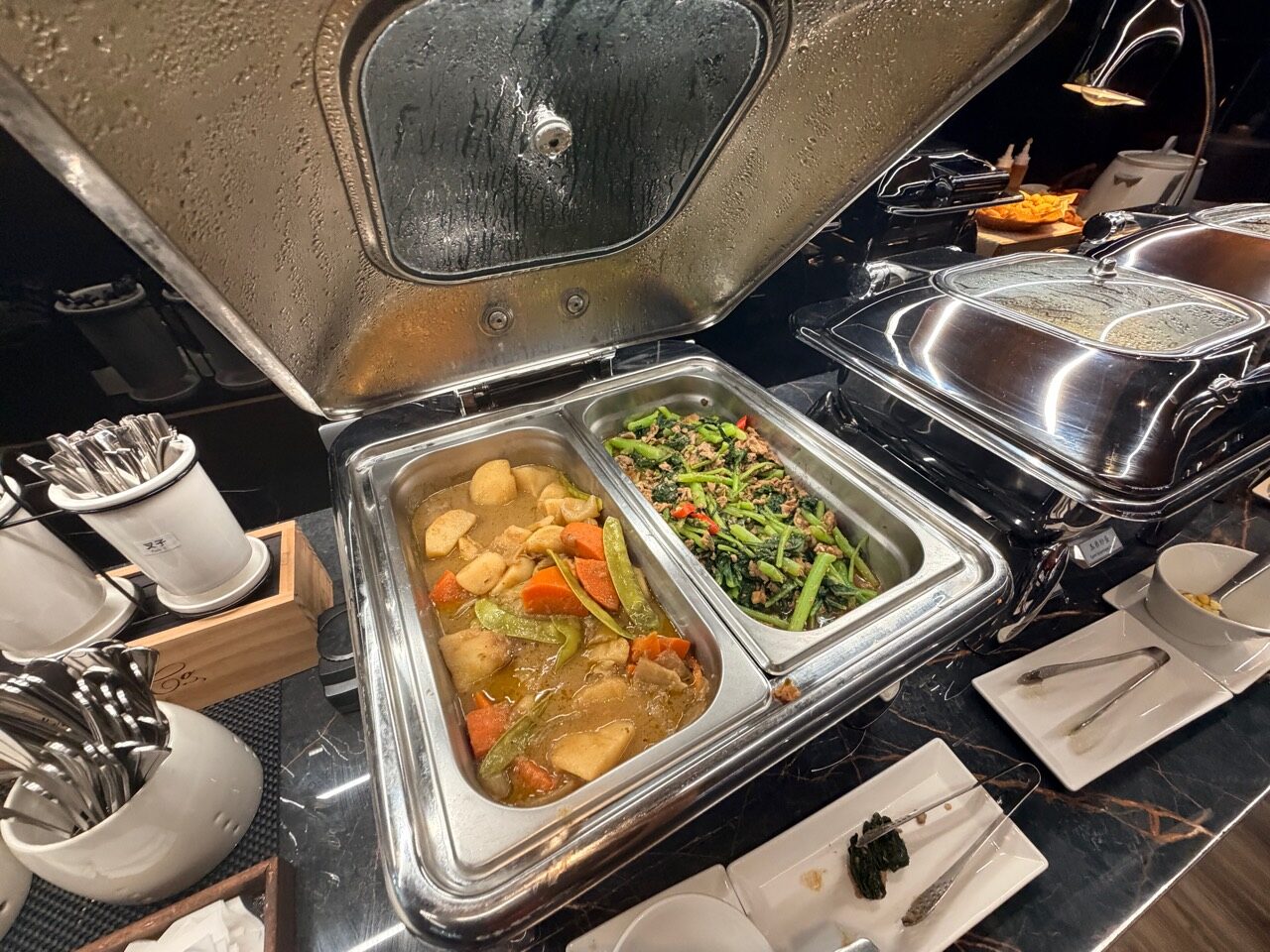 保温容器に入った煮込み料理と青菜。