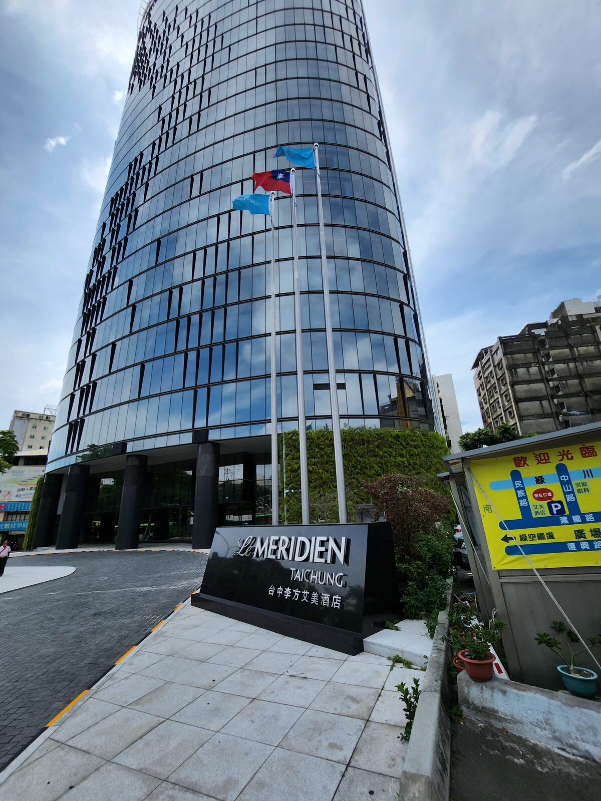 台中李方艾美酒店入口黑色招牌寫著 Le MERIDIEN TAICHUNG 與歡迎光臨地圖看板