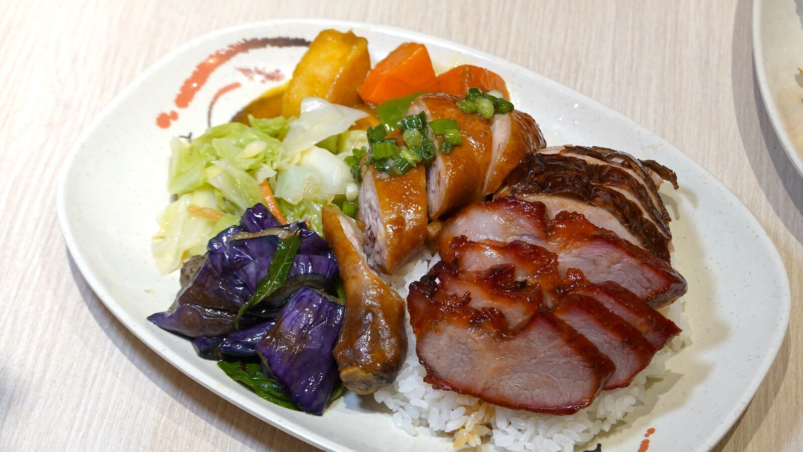 叉燒、雞肉與烤鴨搭配白飯與配菜的三寶飯