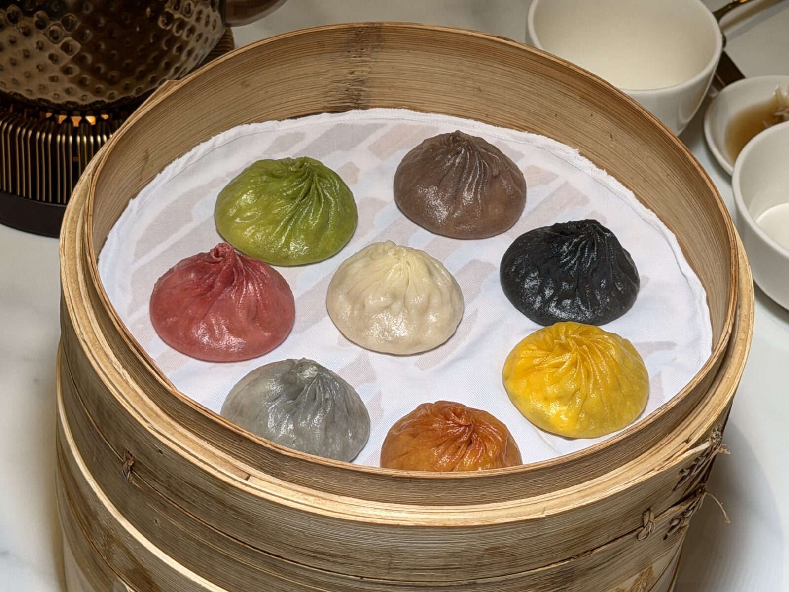 찜기에 담긴 8색 Specialty Dynasty Xiao Long Bao를 위에서 찍은 모습