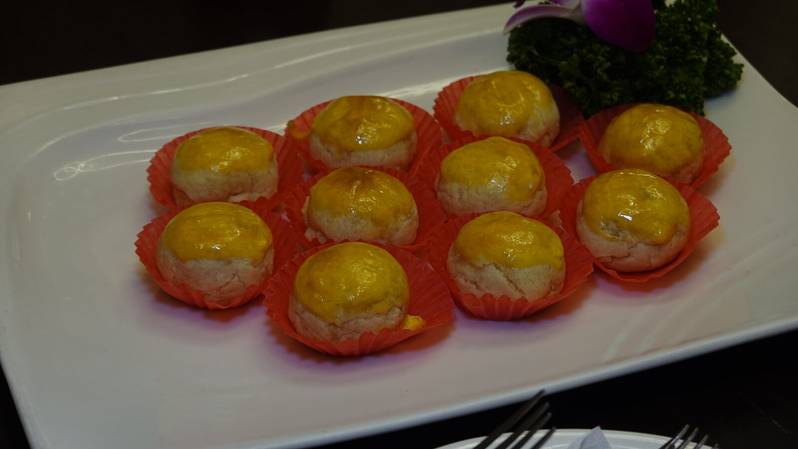 九顆酥皮蛋黃小點心放在紅紙托上