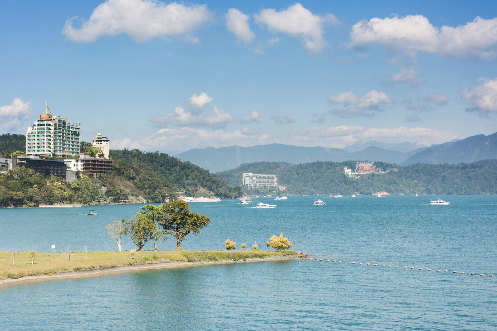 日月潭湖岸草地、湖面、遠處建築與山巒