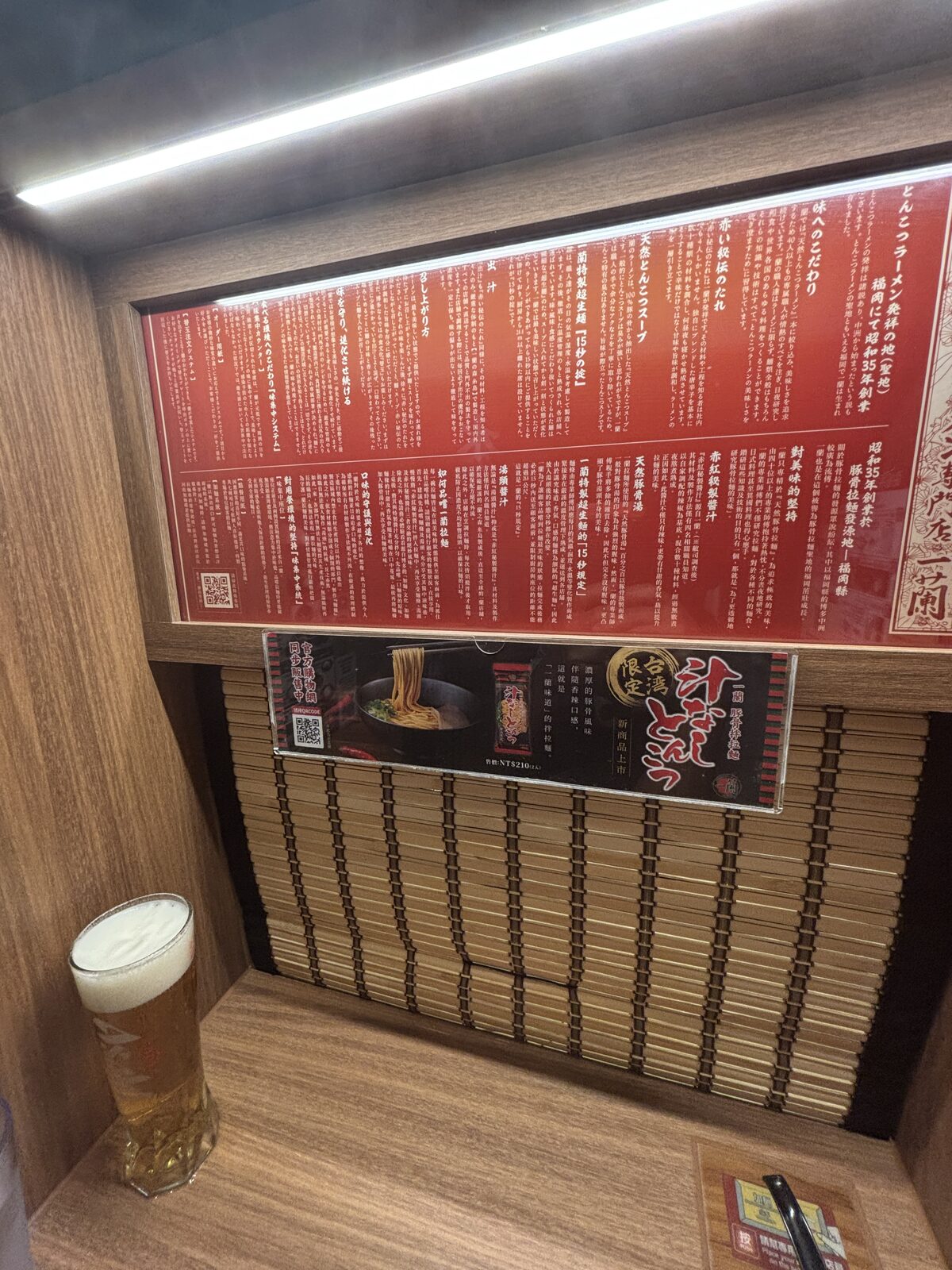 一蘭味集中座位前方的品牌故事紅色說明板與竹簾