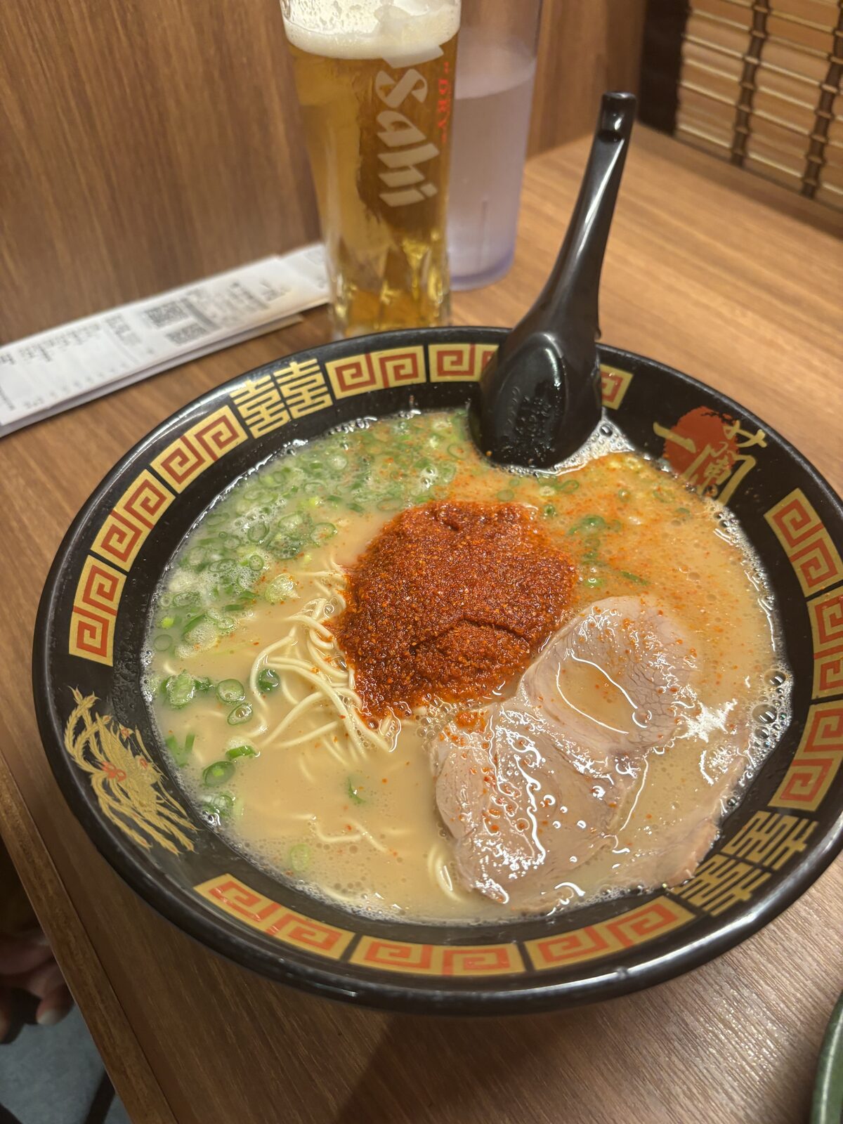 一蘭天然豚骨拉麵，碗中放有叉燒、蔥花與赤紅秘製醬汁