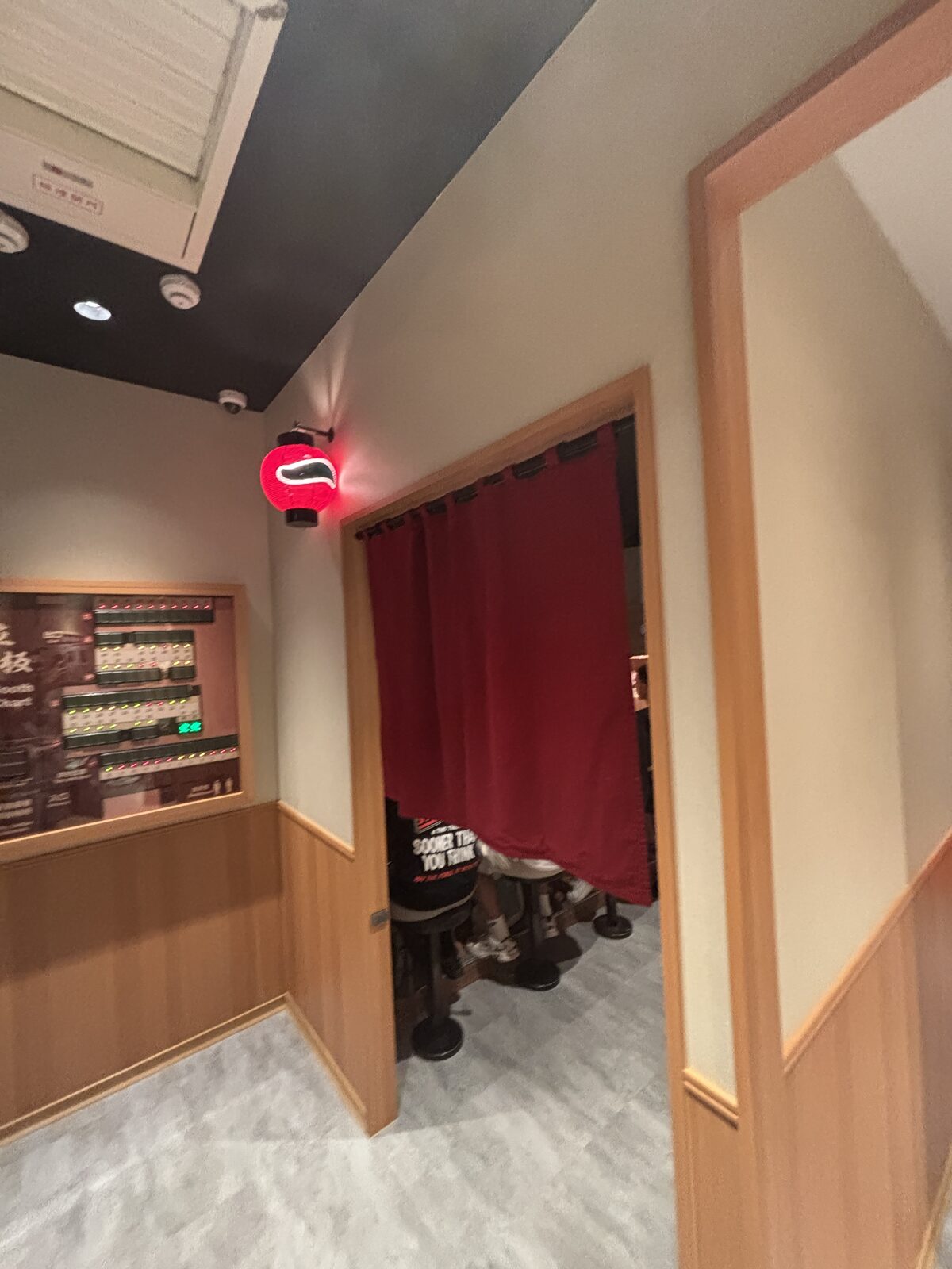 一蘭店內紅色布簾入口與座位狀態顯示區