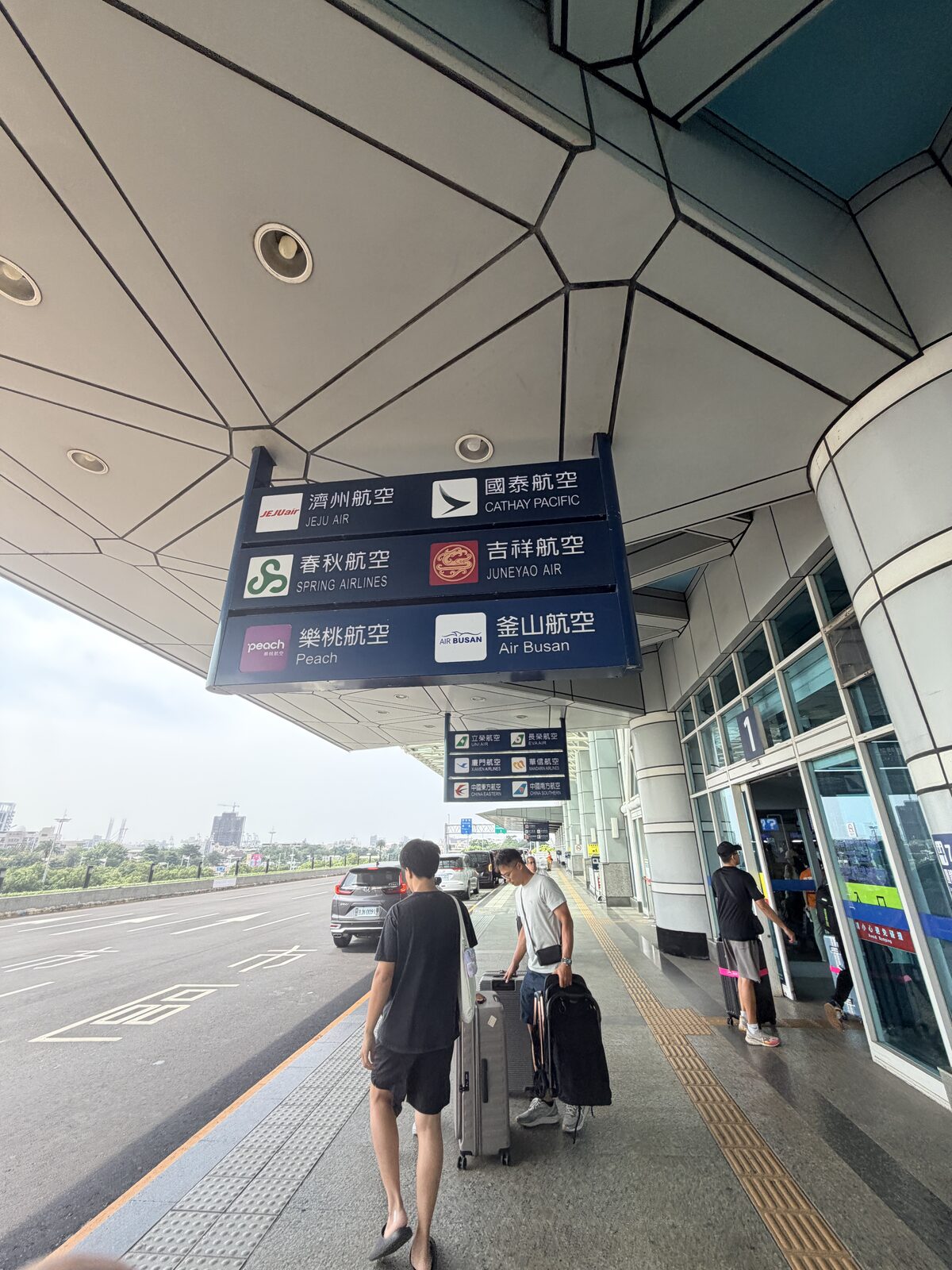 國際航廈外的入口指示牌，列出不同航空公司對應的門號