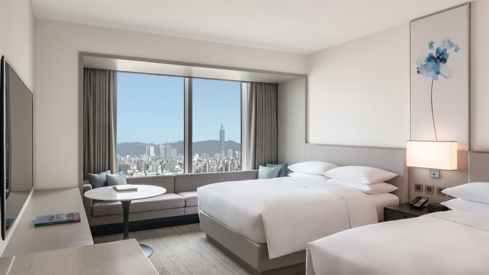 The Taipei cityscape and Taipei 101 in the distance outside the window of a twin room