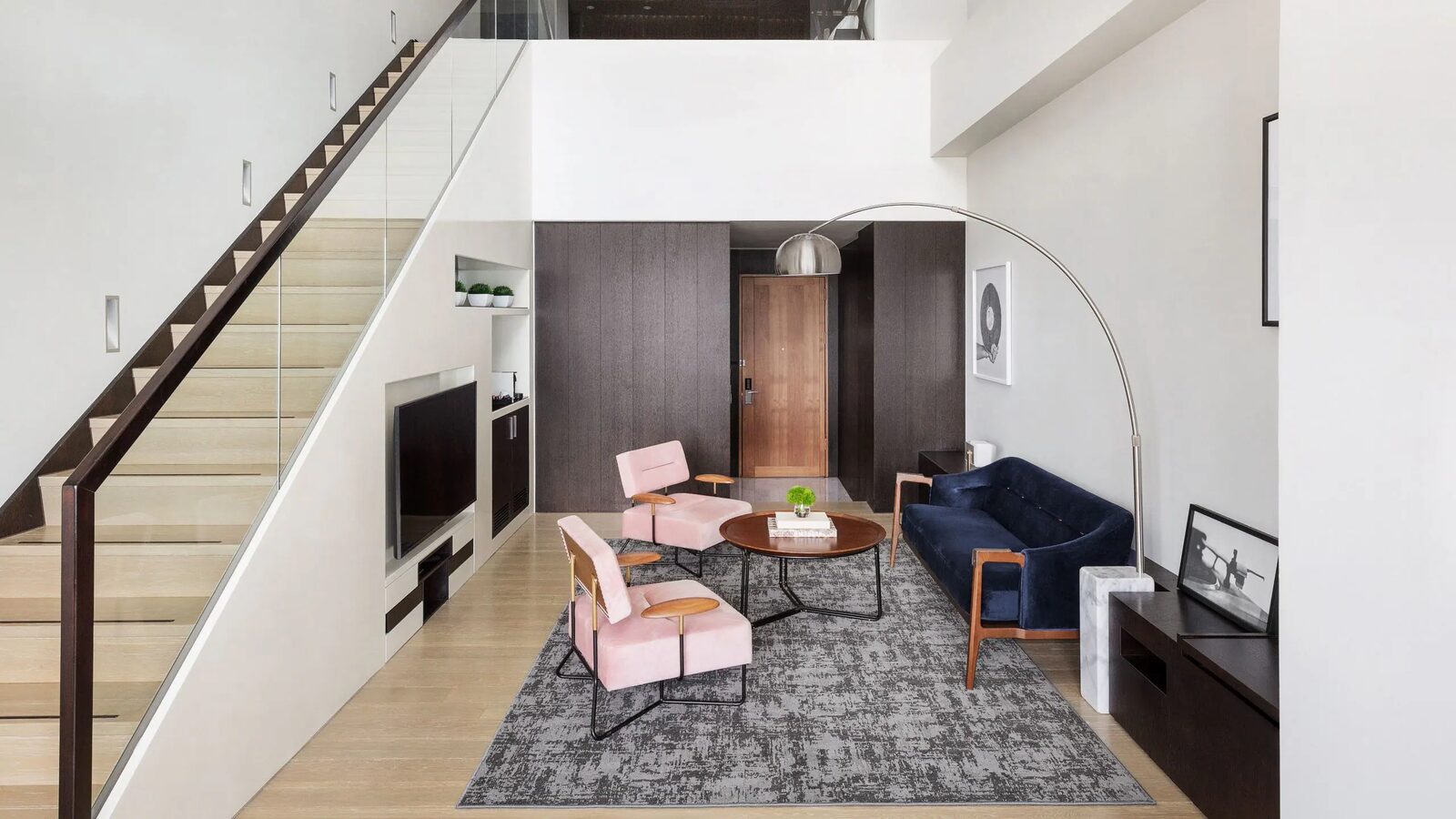 ห้องนั่งเล่นเพดานสูงของห้องสวีท Loft และบันไดขึ้นชั้นบน