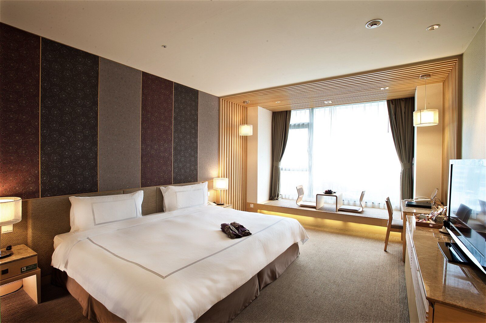 A large bed and window seating in a Western-style guest room
