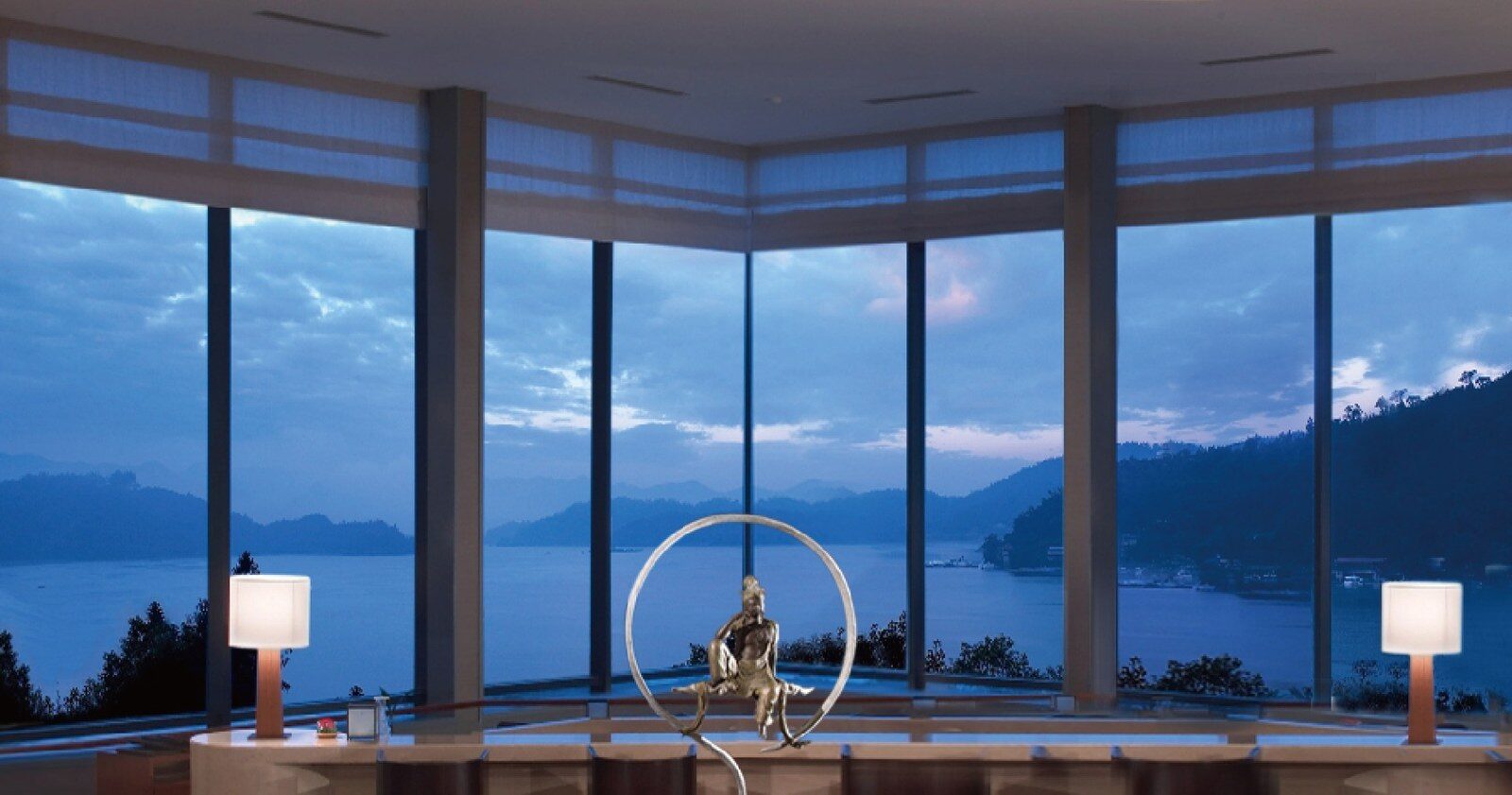 A row of floor-to-ceiling windows facing Sun Moon Lake with a figure sculpture in front