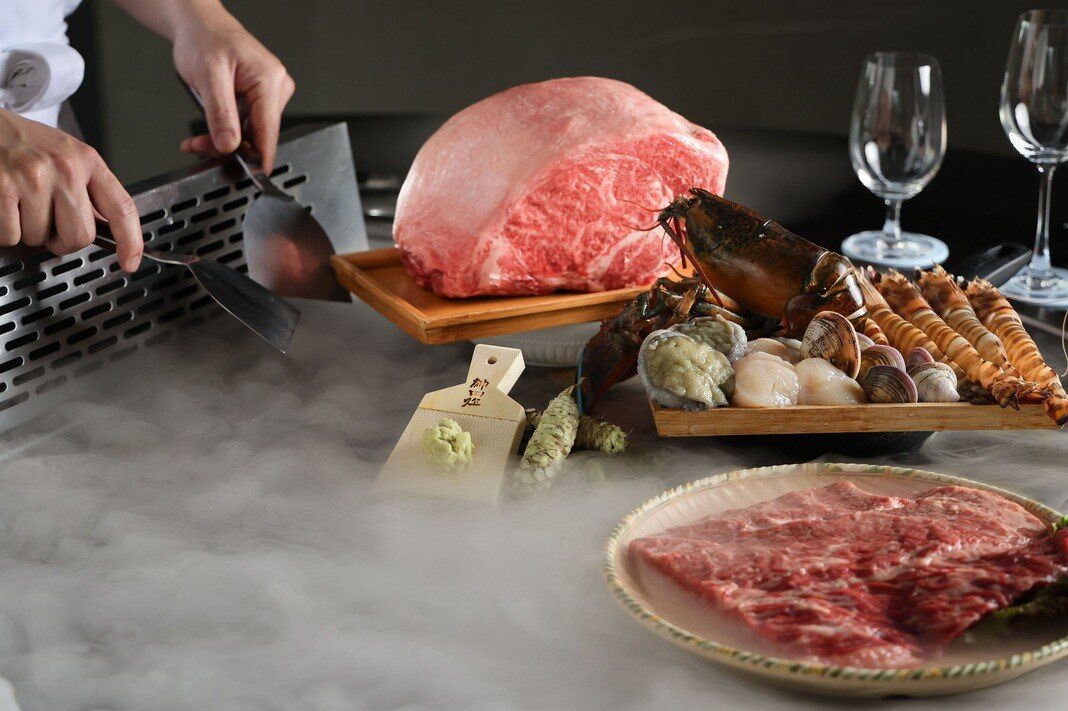 A whole cut of beef, lobster and seafood on a teppanyaki grill