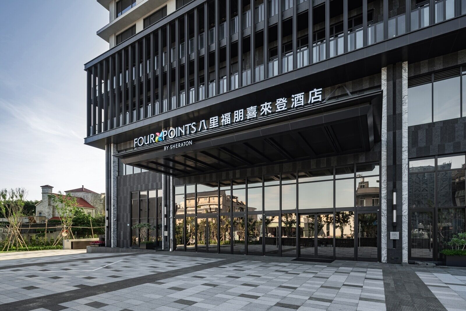 酒店正门的玻璃门廊，上方挂着中英文馆名招牌