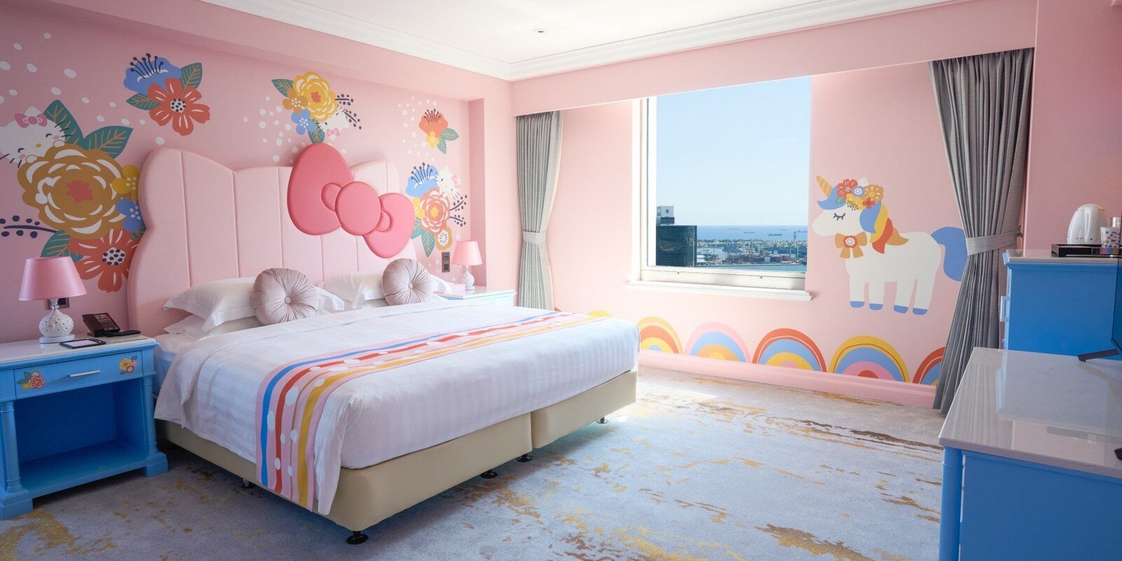 Hello Kitty 主题客房的粉色床头墙与窗外市景
