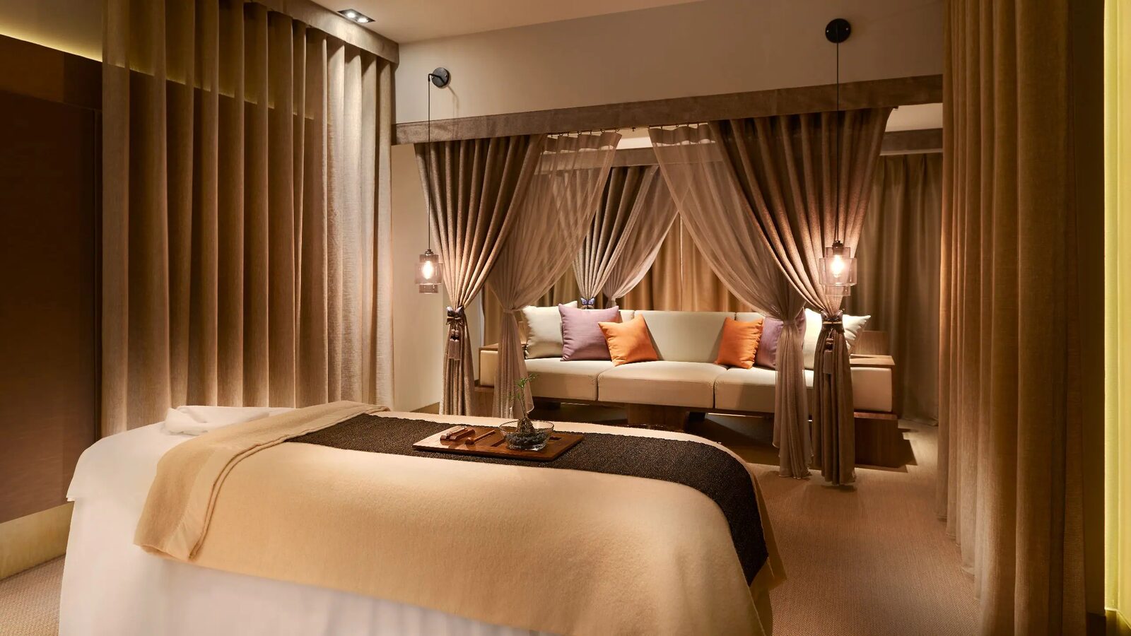 A massage bed and sheer curtains in an Oasis Spa treatment room