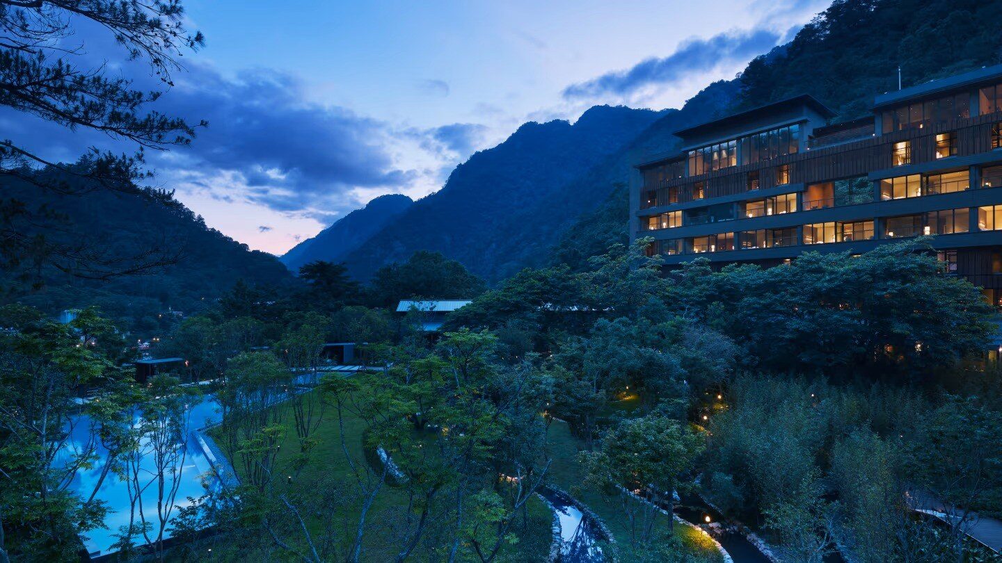 The guest room buildings of HOSHINOYA Guguan and the Water Garden in the valley at dusk