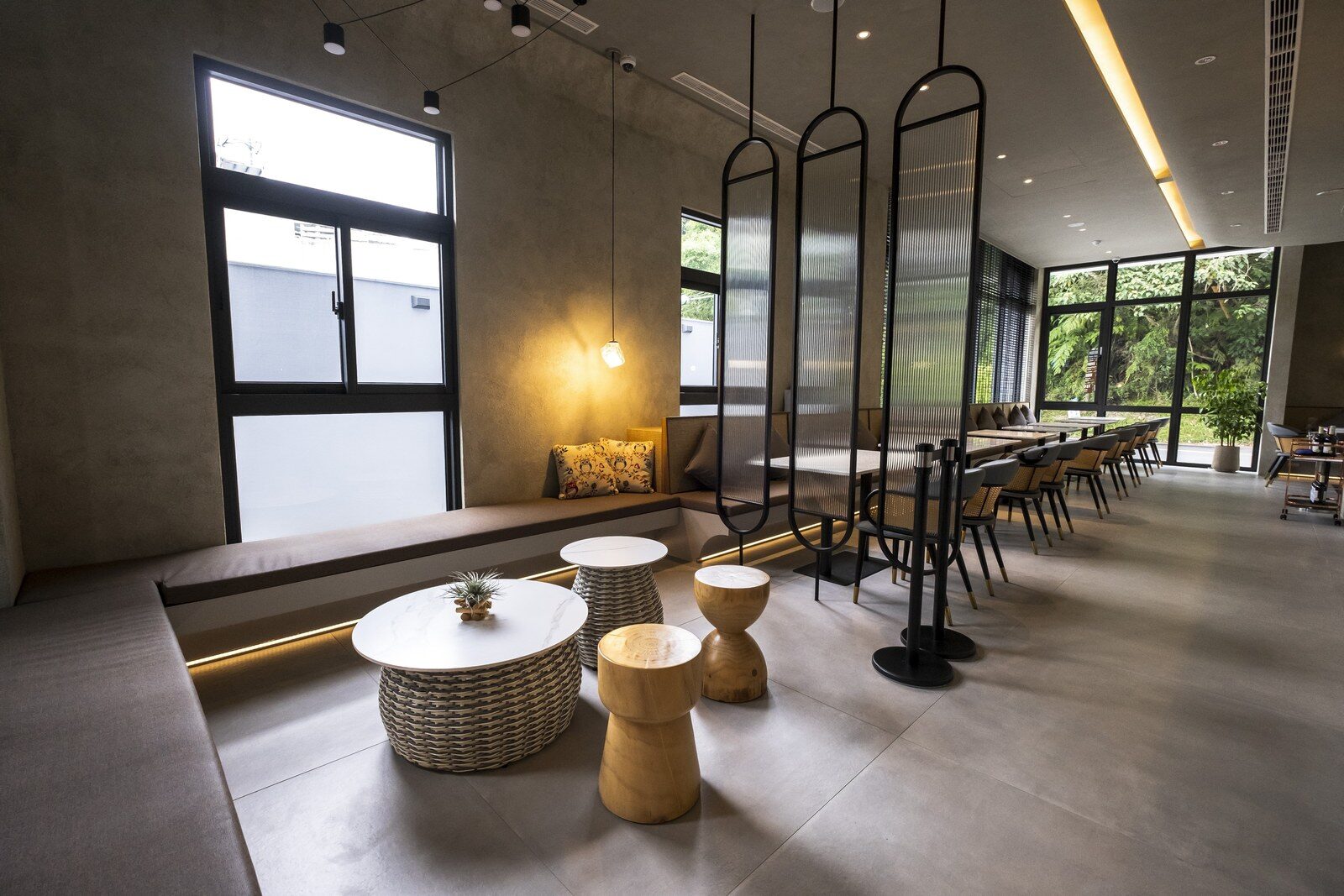 館內用餐空間的長桌、圓凳與整面窗戶