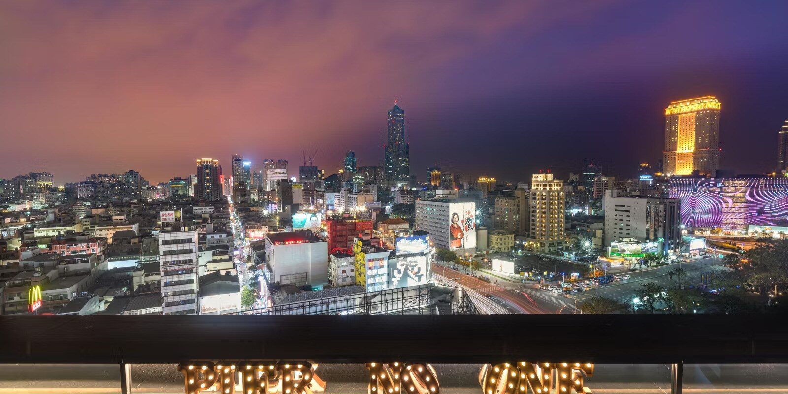 從高處望向高雄市區夜景，街道燈火一路延伸到遠方的高樓