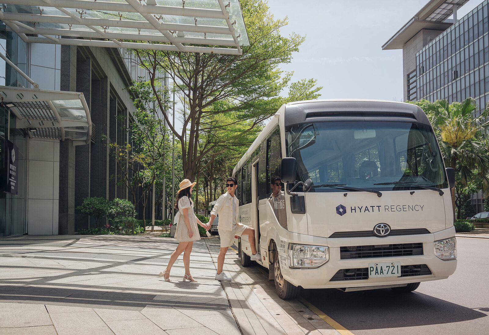 A Hyatt Regency shuttle bus at the hotel entrance with guests boarding