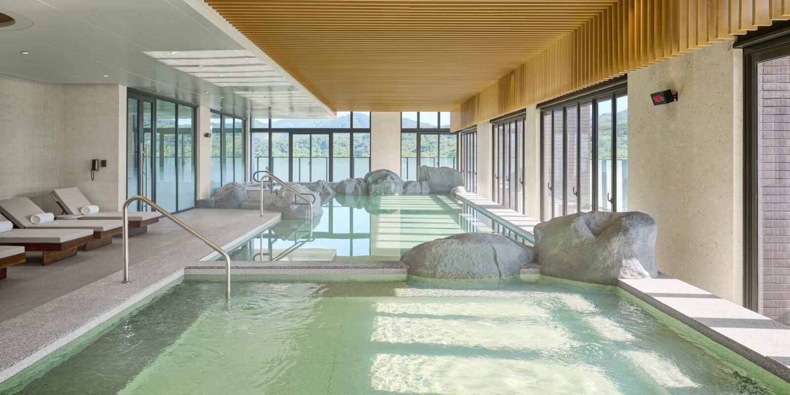 室內溫泉池、池畔躺椅與整面落地窗