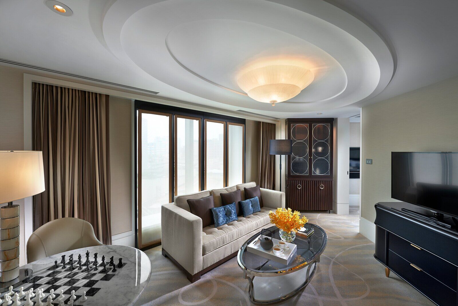The sofa area and floor-to-ceiling windows in a suite living room at Mandarin Oriental, Taipei