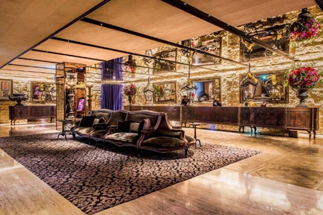 Velvet sofas, a patterned carpet and mirrored walls in the lobby of Palais de Chine Hotel
