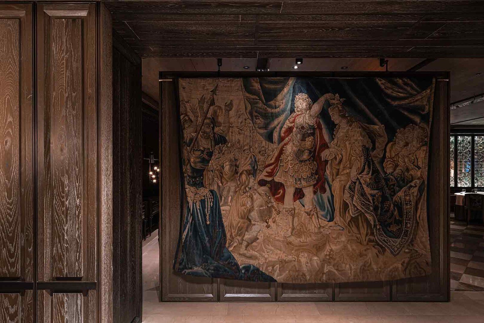 A large classical tapestry of figures in a wooden display frame