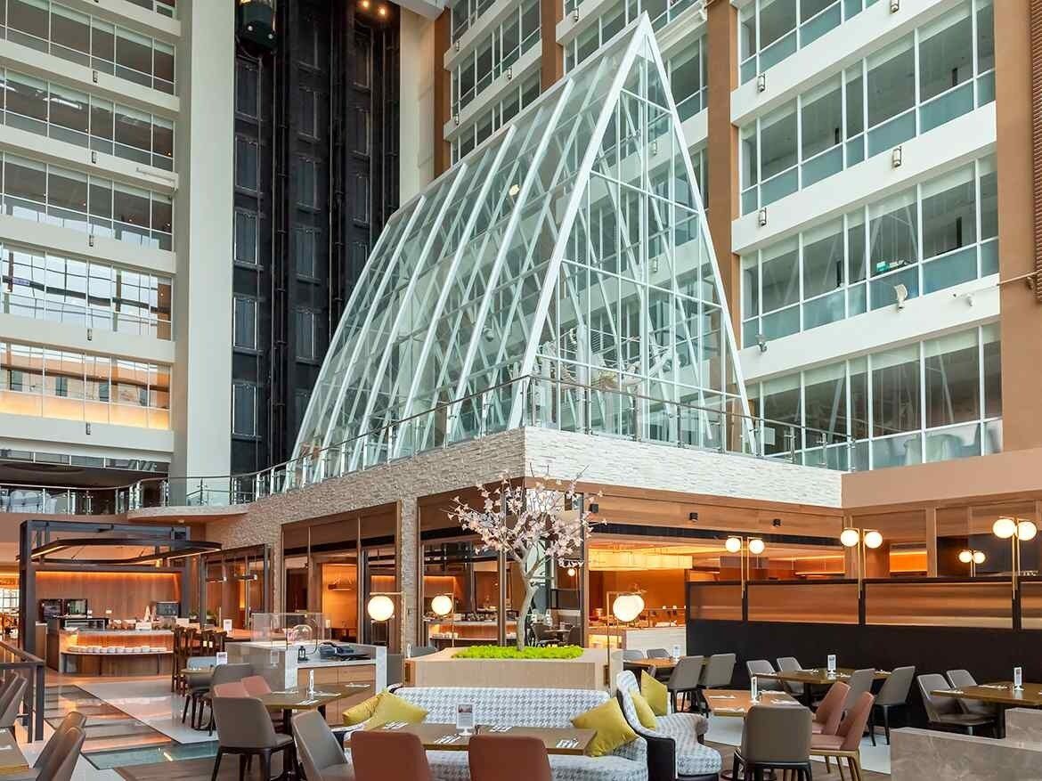 玻璃尖頂中庭下的優廚西餐廳自助餐檯與座位區