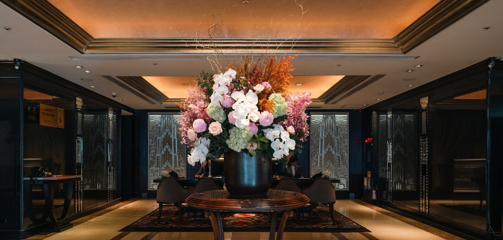 A large floral arrangement and dark walls in the hotel's entrance hall