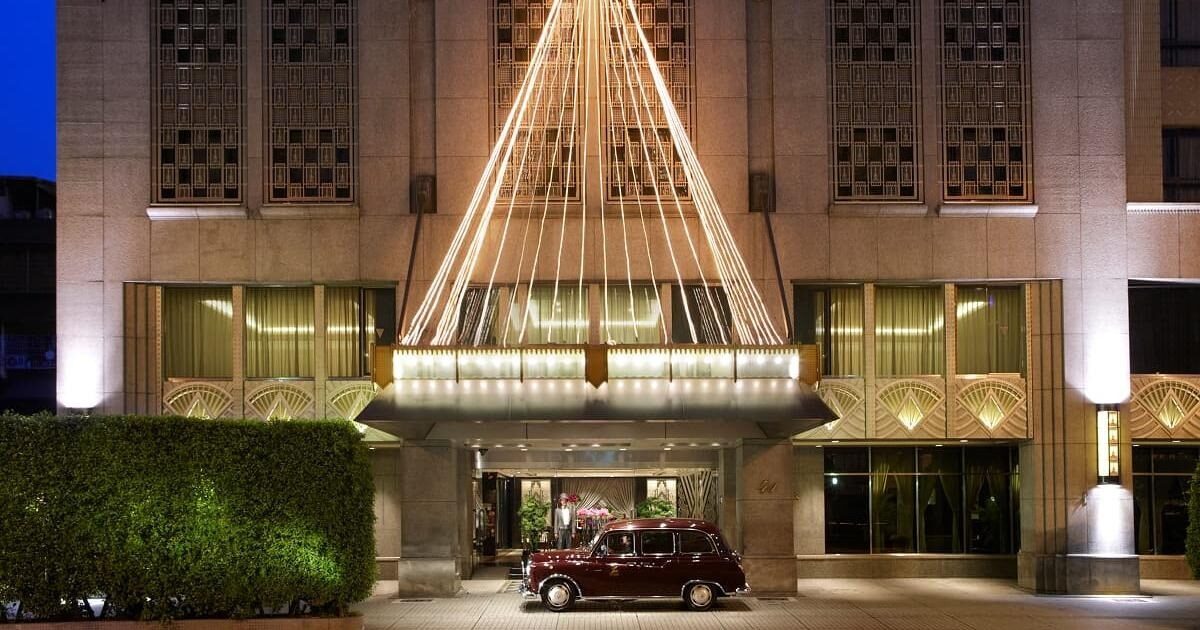 The main entrance of The Landis Taipei at night, with a vintage car out front