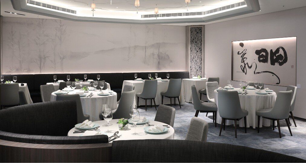 White round tables and calligraphy on the wall in the Tien Hsiang Lo dining room