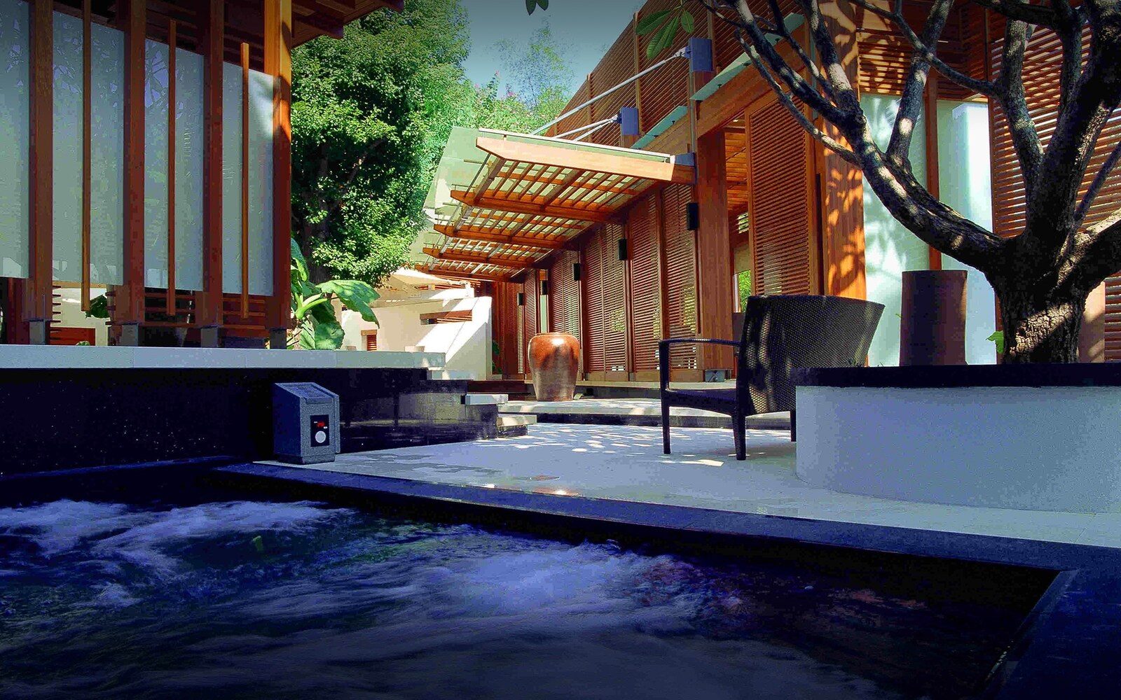 An outdoor hot spring pool and the wooden-louvered exterior of Villa 32